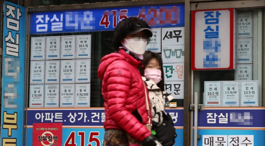 시민들이 부동산공인중개업소 매물정보 게시판 앞을 지나가고 있다. <연합뉴스>